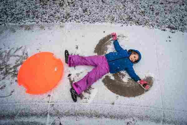 Child with sled in snow
